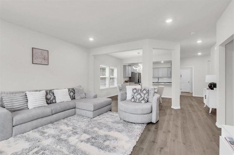 Living area featuring light wood finished floors, recessed lighting, and baseboards Living area featuring light wood finished floors, recessed lighting, and baseboards