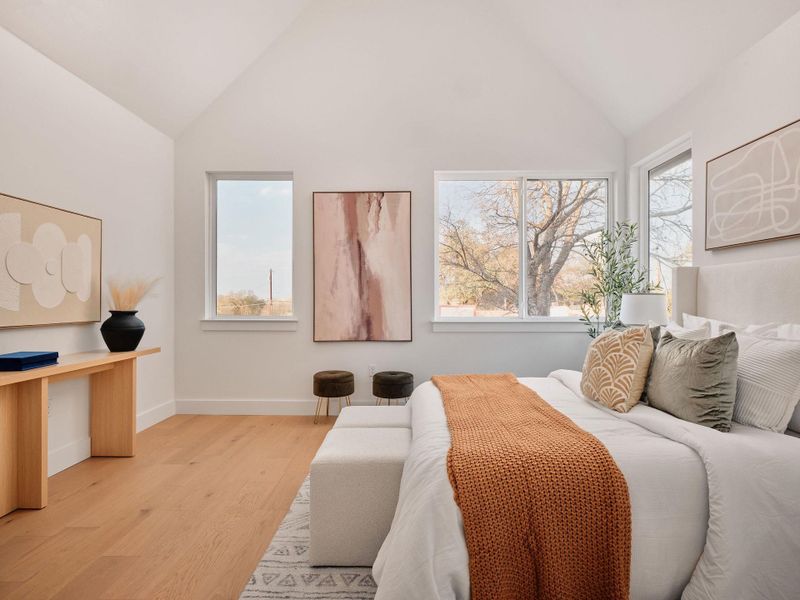 Bedroom with lofted ceiling and light wood-style flooring