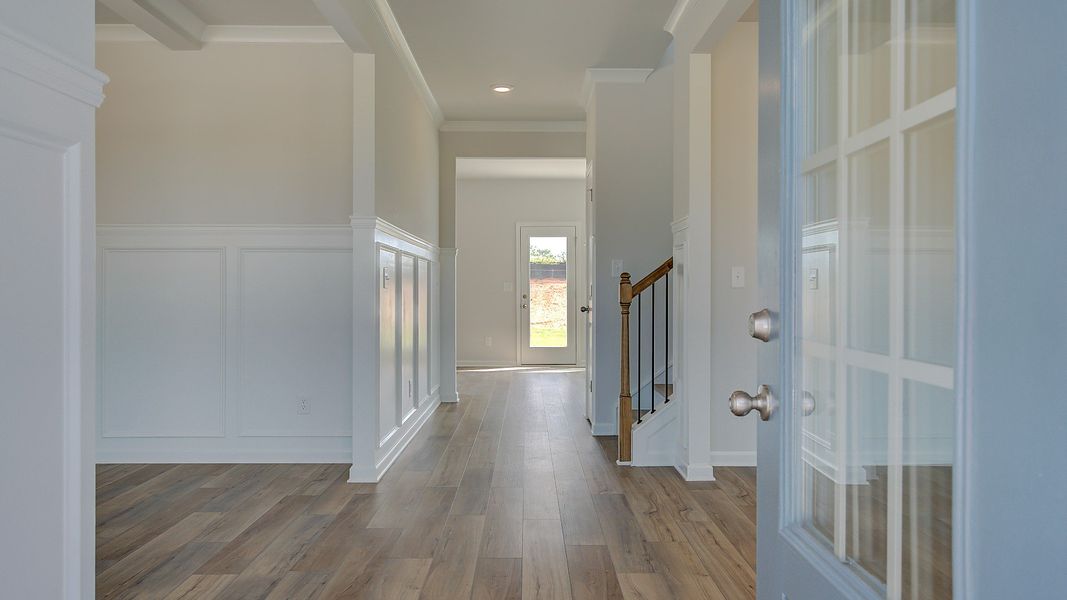 Stonefield entry with neutral front door, LVP flooring, and open foyer at Brighton in Locust Grove, GA.