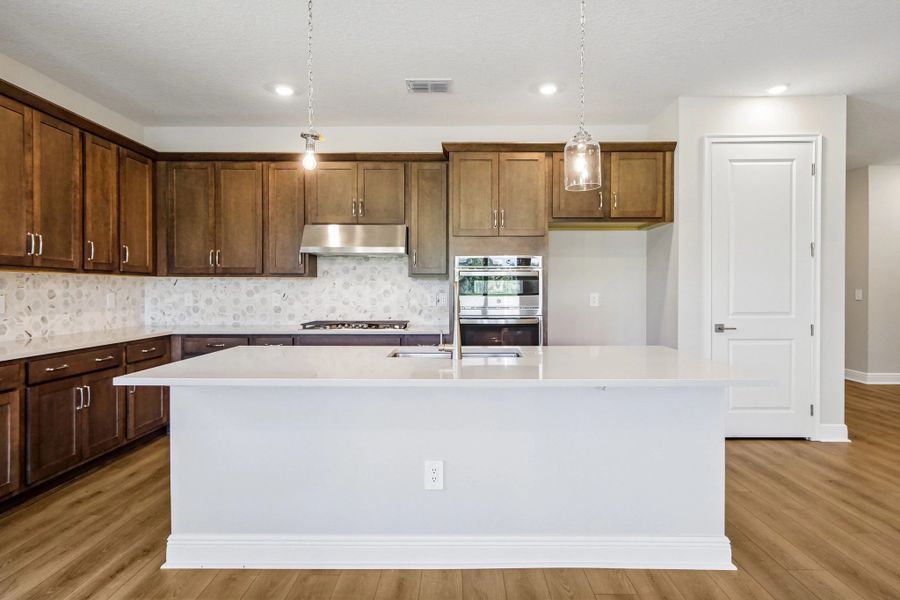 The kitchen features AW Collection® Roosevelt and a large island centers the space