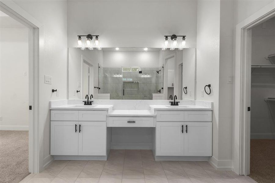 This bathroom features a double vanity with white cabinetry, light-colored countertops, and matte black fixtures