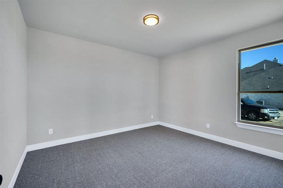 Empty room featuring dark colored carpet