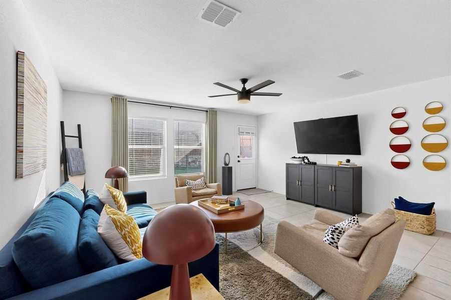 Living room featuring light tile patterned floors and a ceiling fan Living room featuring light tile patterned floors and a ceiling fan