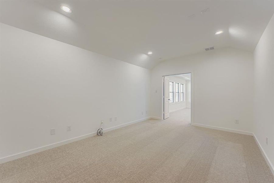 Empty room with light colored carpet, recessed lighting, and vaulted ceiling Empty room with light colored carpet, recessed lighting, and vaulted ceiling