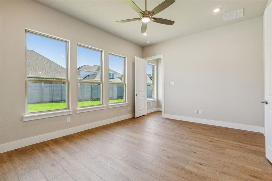 Unfurnished room featuring light wood-type flooring and ceiling fan