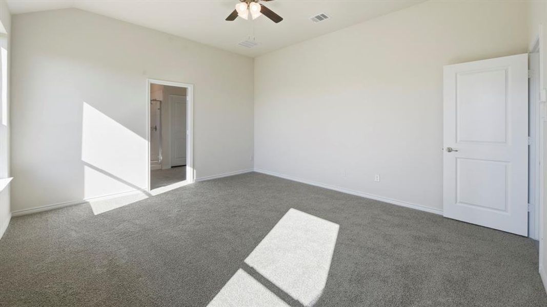 Unfurnished bedroom with carpet flooring, ceiling fan, and vaulted ceiling
