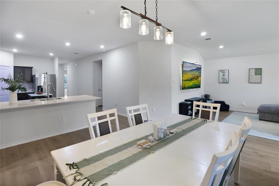 Dining room with dark wood-type flooring and recessed lighting