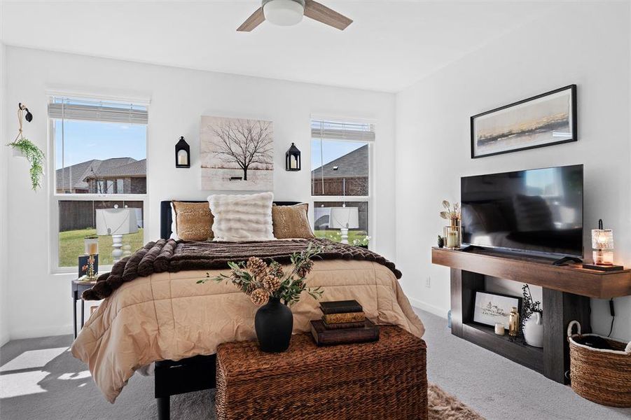 Carpeted primary bedroom featuring ceiling fan Carpeted primary bedroom featuring ceiling fan