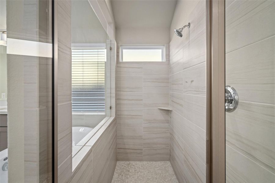 Generously sized Primary Shower with modern tile surround and glass enclosure.