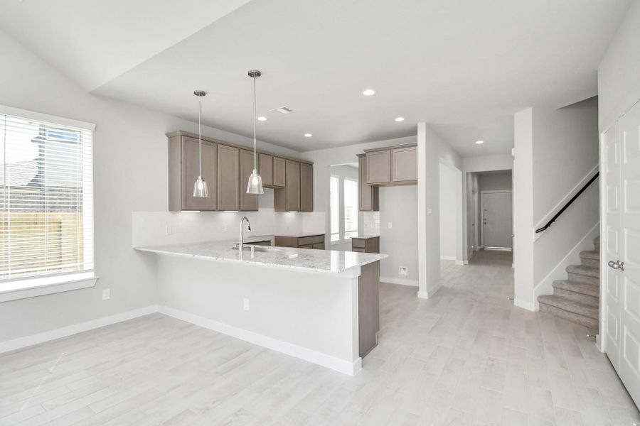 Discover another perspective of this stunning kitchen, generously appointed with an abundance of counter space.