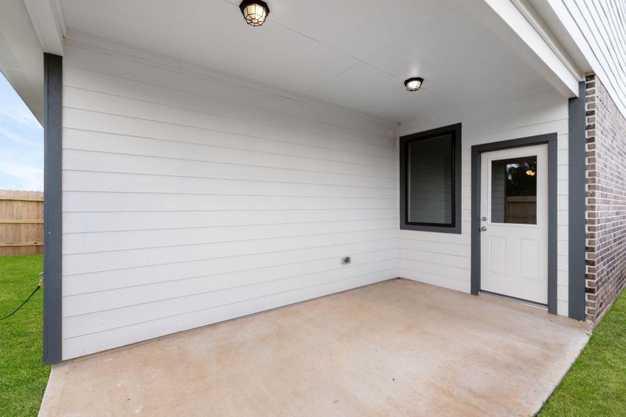 The covered patio is generously sized, providing ample space for various outdoor activities.