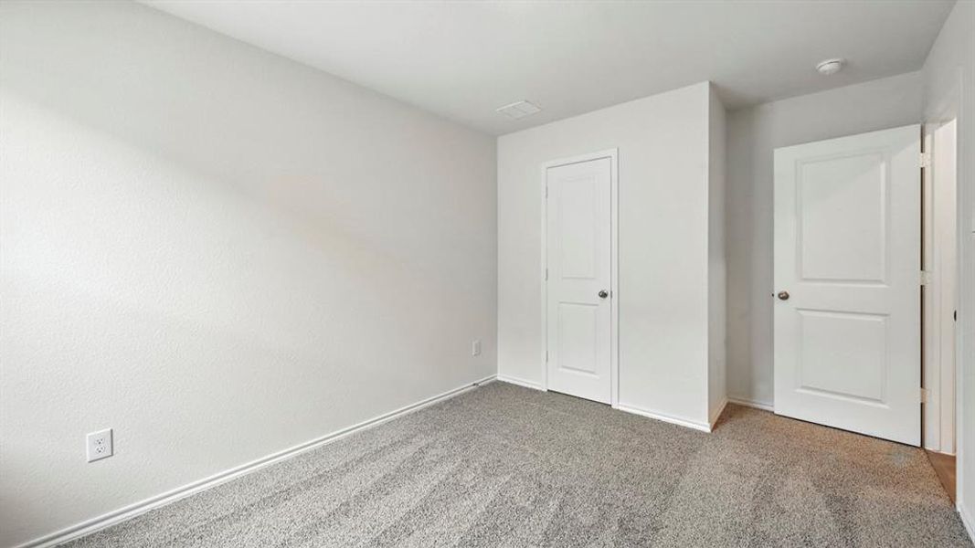Room featuring light gray textured carpeting and white baseboards Room featuring light gray textured carpeting and white baseboards
