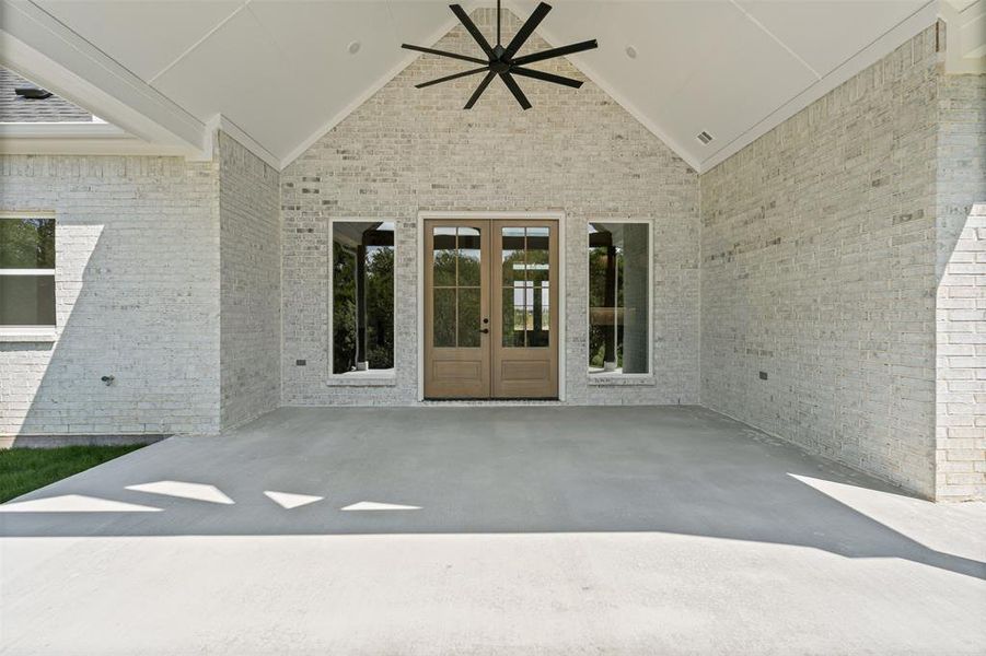 french doors, a patio area, brick siding, and ceiling fan french doors, a patio area, brick siding, and ceiling fan