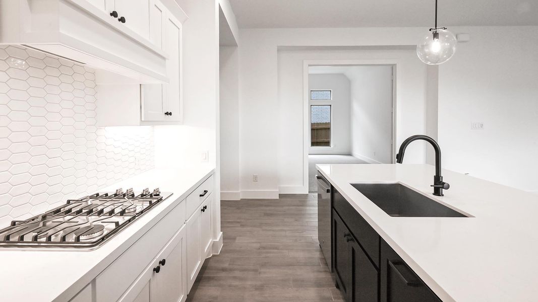 Kitchen with a sink, stainless steel appliances, light countertops, and white cabinetry Kitchen with a sink, stainless steel appliances, light countertops, and white cabinetry