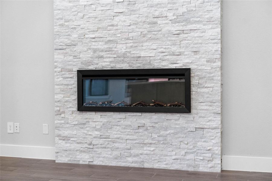 This linear electric fireplace serves as a sleek, contemporary focal point with Arctic White stacked-stone surround.