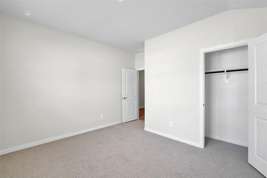 Unfurnished bedroom featuring carpet flooring and a closet Unfurnished bedroom featuring carpet flooring and a closet
