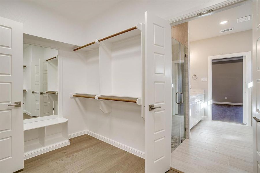 Spacious closet with light hardwood / wood-style flooring