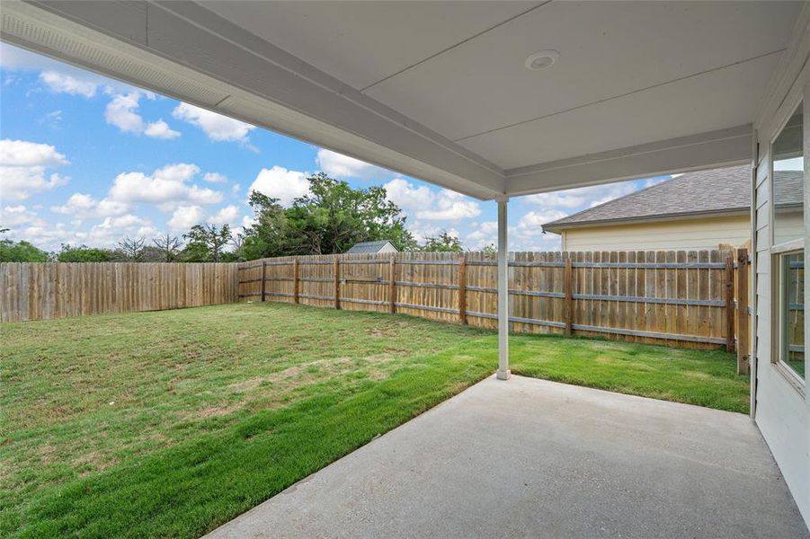 Fenced backyard featuring a patio area Fenced backyard featuring a patio area