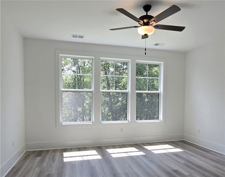 Three generous windows illuminate the primary bedr
