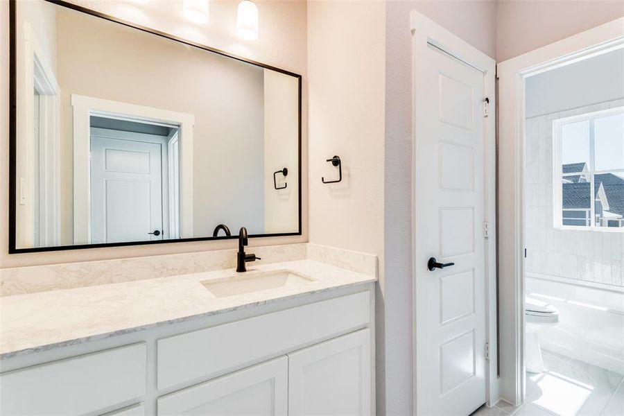 Full bathroom featuring tile patterned flooring, washtub / shower combination, toilet, and vanity