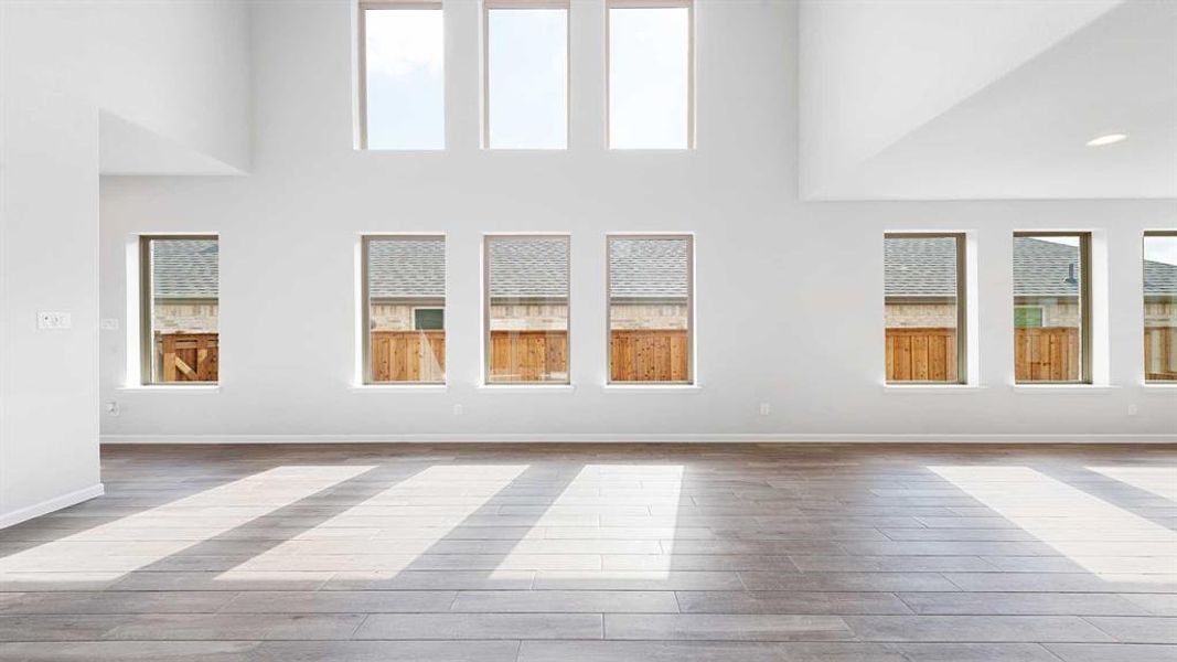 Unfurnished living room featuring high vaulted ceiling and light hardwood / wood-style flooring