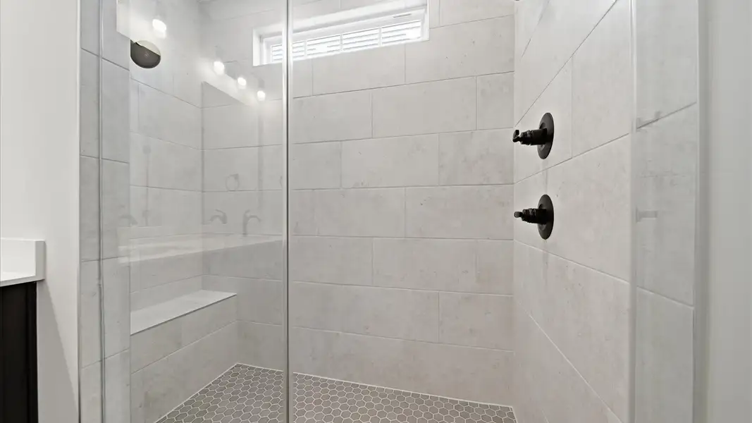 Exceptional en-suite with dual vanity and glass-enclosed walk-in shower for superior everyday comfort at Iris Meadows