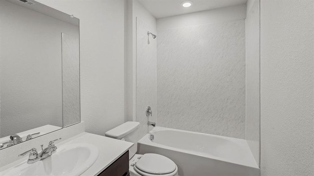 Bathroom featuring a white vanity with an integrated sink, chrome faucet, and a large wall-mounted mirror