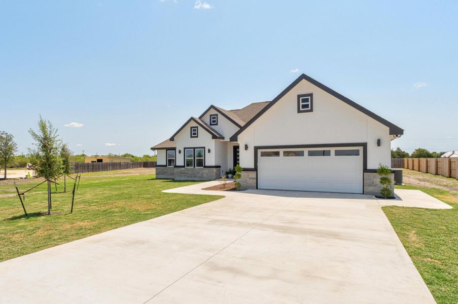Modern farmhouse style home featuring stucco siding, stone siding, concrete driveway, and an attached garage Modern farmhouse style home featuring stucco siding, stone siding, concrete driveway, and an attached garage