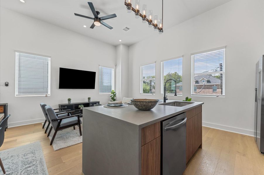 The heart of the second-floor open-concept living, dining, and kitchen, this spacious kitchen island features sleek modern finishes, including a one-sided cascade quartz countertop, a farmhouse sink, and stylish pendant lighting, with a built-in seating area perfect for casual breakfasts or chatting with family and friends.