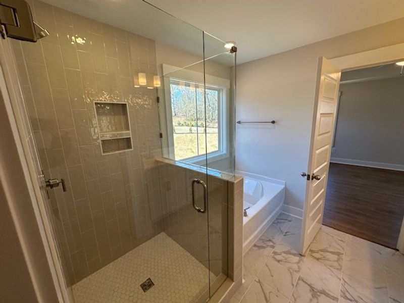 This bathroom features a sleek glass-enclosed show