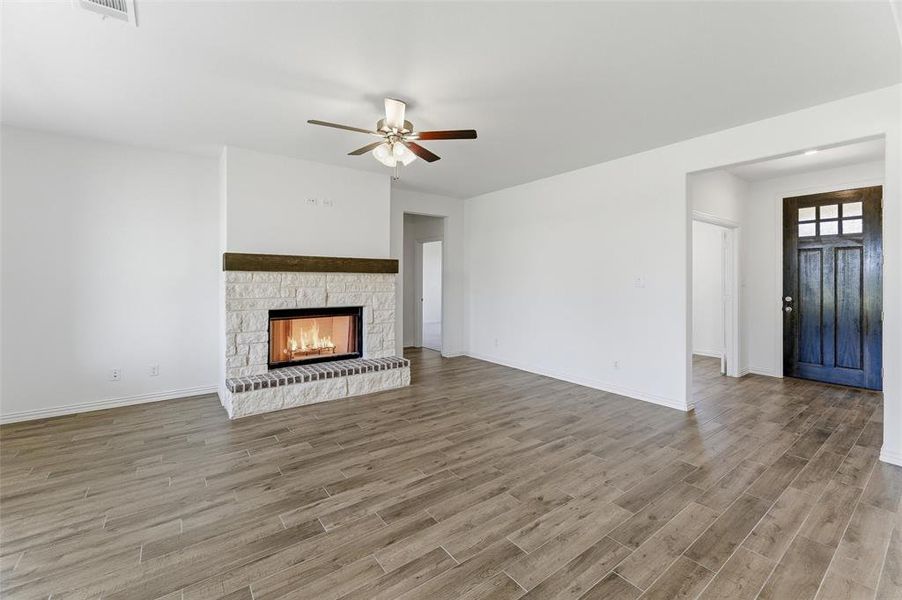 Living area featuring a stone-clad fireplace with a wood mantel