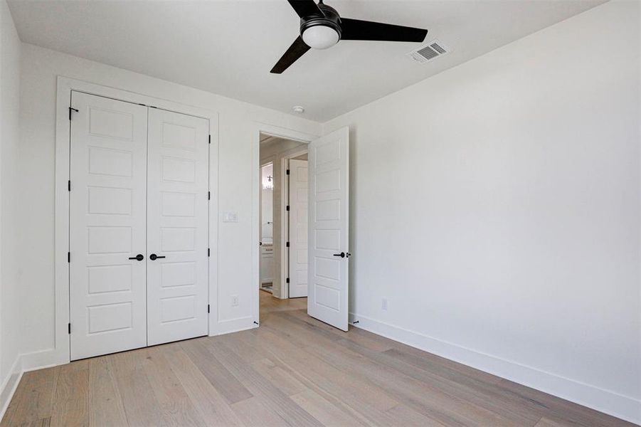 Unfurnished bedroom with ceiling fan, light hardwood / wood-style floors, and a closet