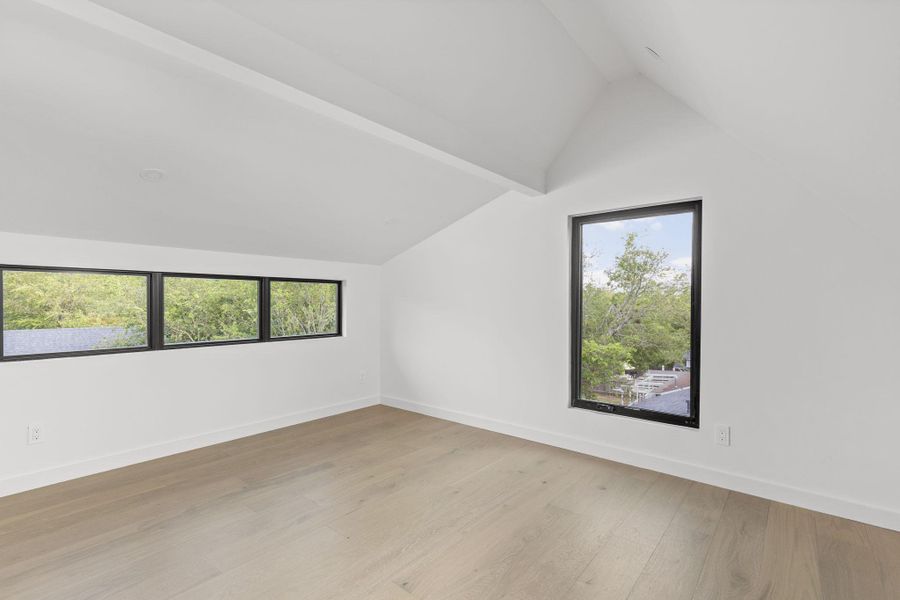 Additional living space with lofted ceiling and light wood-type flooring
