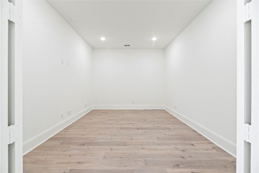 This game room offers endless possibilities with its spacious layout, neutral design, and recessed lighting. Perfect for a media lounge, playroom, home gym, or hobby space.