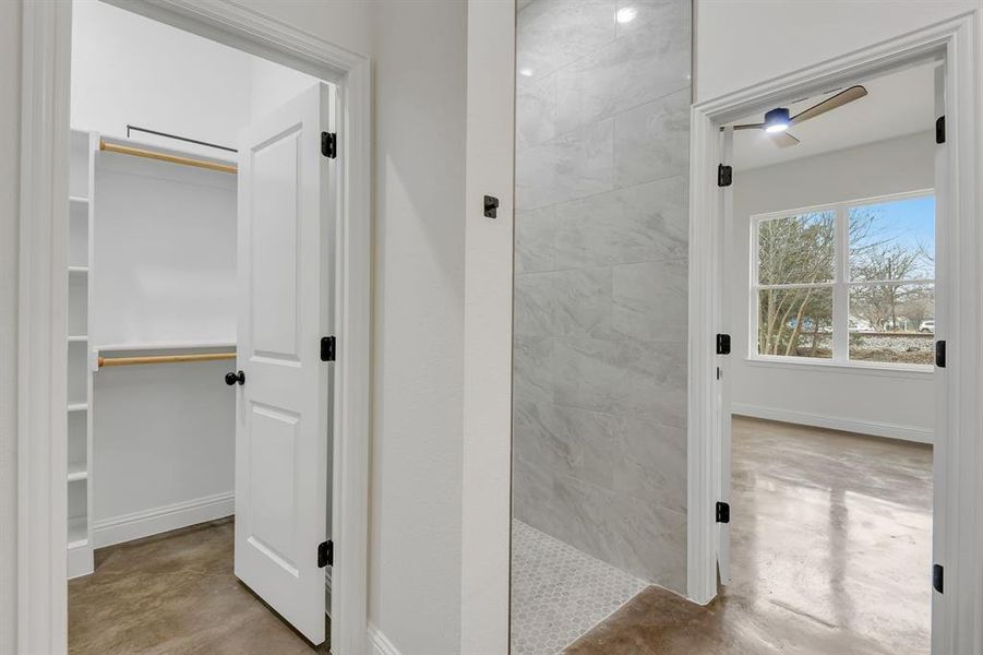 Bathroom with concrete floors and a walk in closet