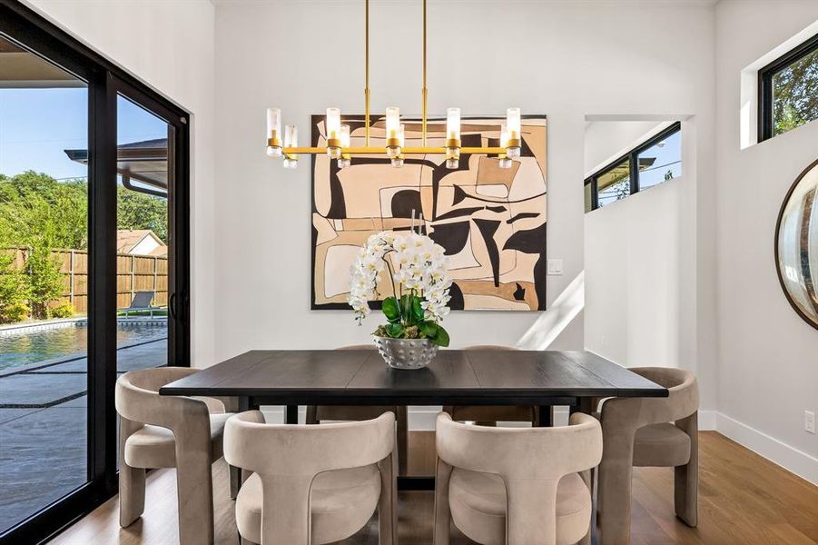 Dining space featuring wood finished floors and a chandelier Dining space featuring wood finished floors and a chandelier