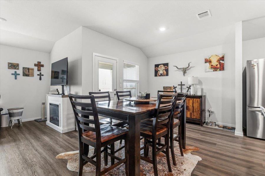 Dining space with lofted ceiling, dark wood-type flooring, and recessed lighting