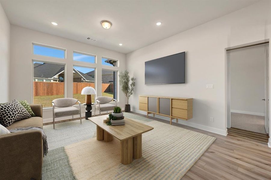 Living room with light wood-type flooring and recessed lighting