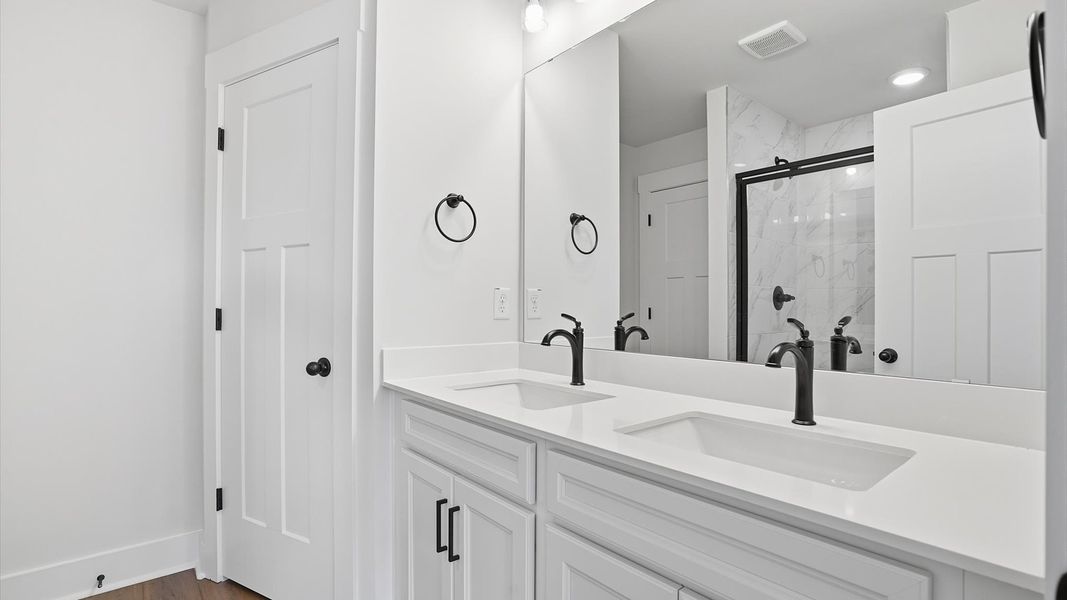 First-rate primary bathroom offering an elegant walk-in shower and dual sinks with superior style at Barton Hollow First-rate primary bathroom offering an elegant walk-in shower and dual sinks with superior style at Barton Hollow