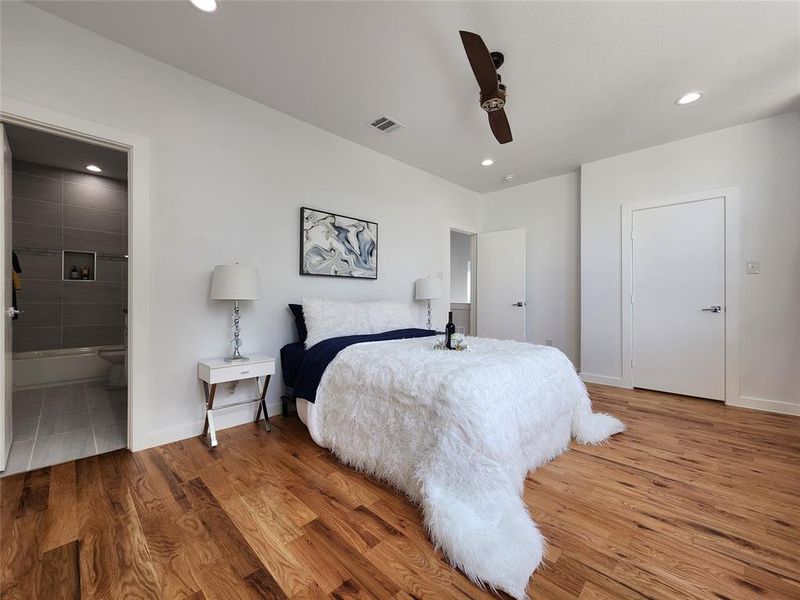 Bedroom featuring ceiling fan, connected bathroom, and wood-type flooring