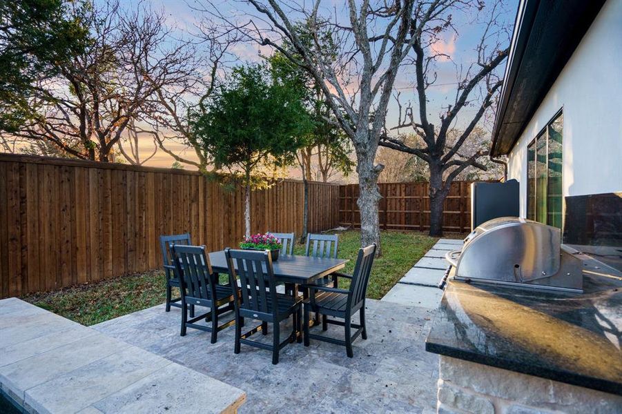 Patio terrace at dusk featuring area for grilling