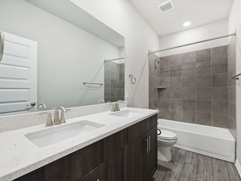 Two of the secondary bedrooms share a bathroom with dual sinks.