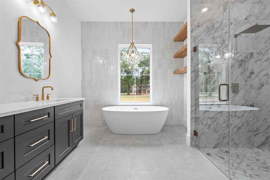 Stunning primary bath with double vanities, oval vessel tub, floating shelves, floor to ceiling tile, large walk in shower and private water closet.