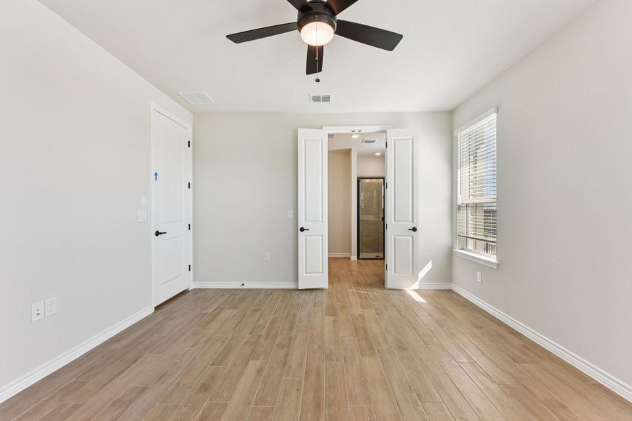 Unfurnished bedroom featuring ceiling fan and light wood-type flooring