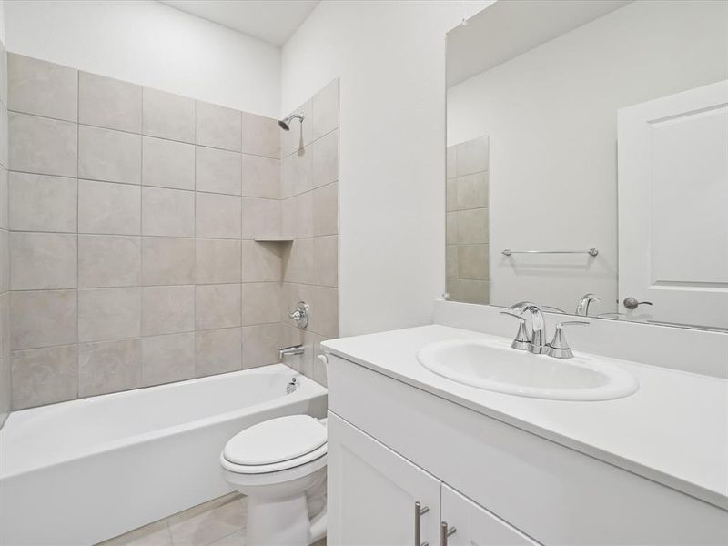 Full bath featuring vanity, shower / tub combination, and light tile patterned floors