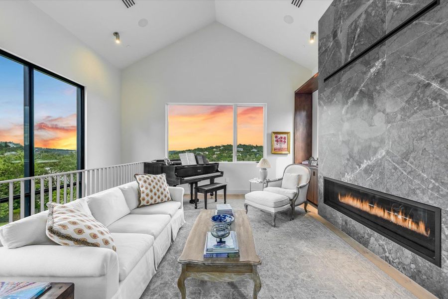 Living area featuring a fireplace and high vaulted ceiling