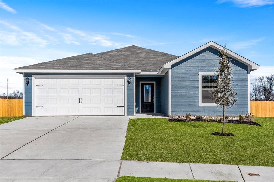 Ranch-style home featuring a garage and a front lawn