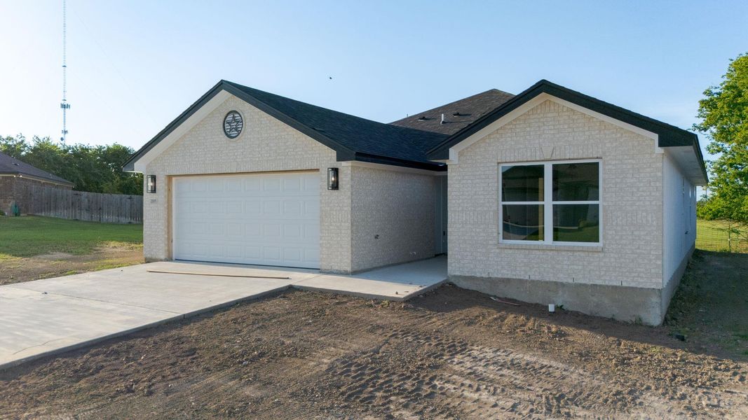 Single story home featuring brick siding, an attached garage, driveway, and roof with shingles Single story home featuring brick siding, an attached garage, driveway, and roof with shingles