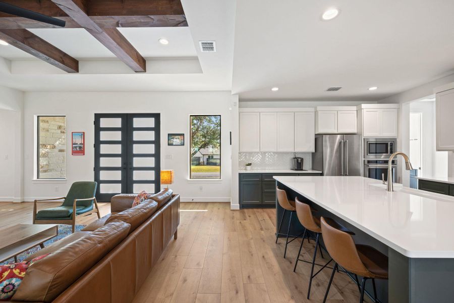 Living room with recessed lighting, light wood-type flooring, and beam ceiling