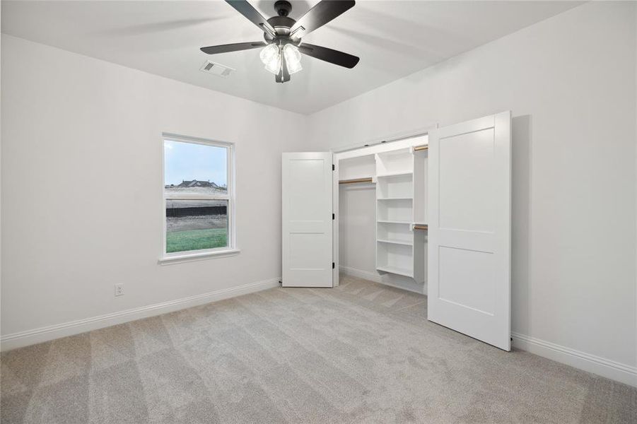 Unfurnished bedroom with a closet, light carpet, and ceiling fan